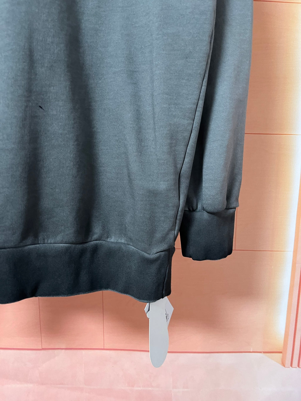 Dark teal sweatshirt side view with ribbed sleeve cuff and hem