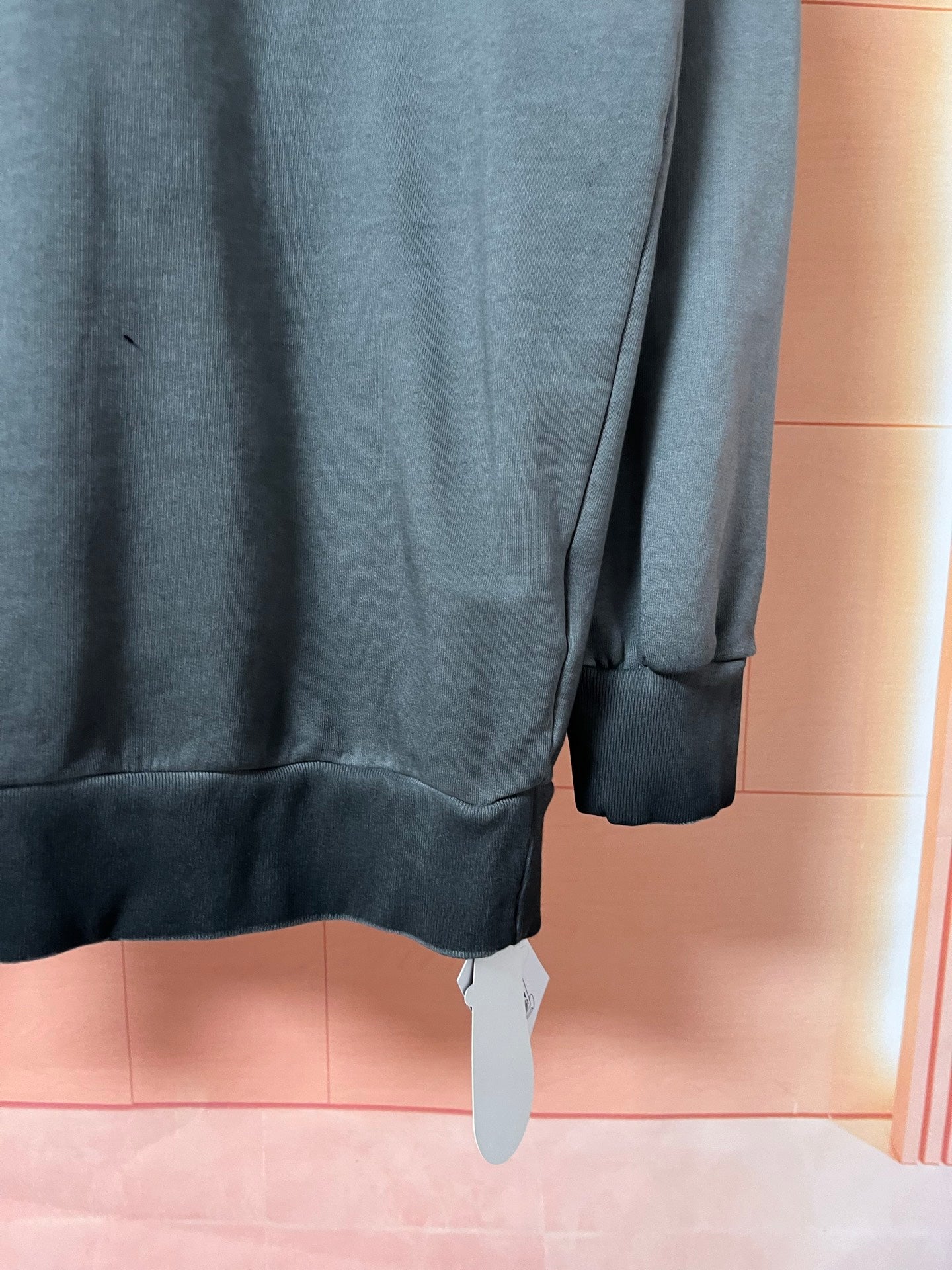 Dark teal sweatshirt side view with ribbed sleeve cuff and hem