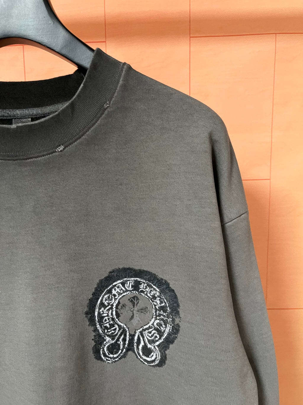 Dark teal long-sleeve sweatshirt with embroidered-looking chest emblem