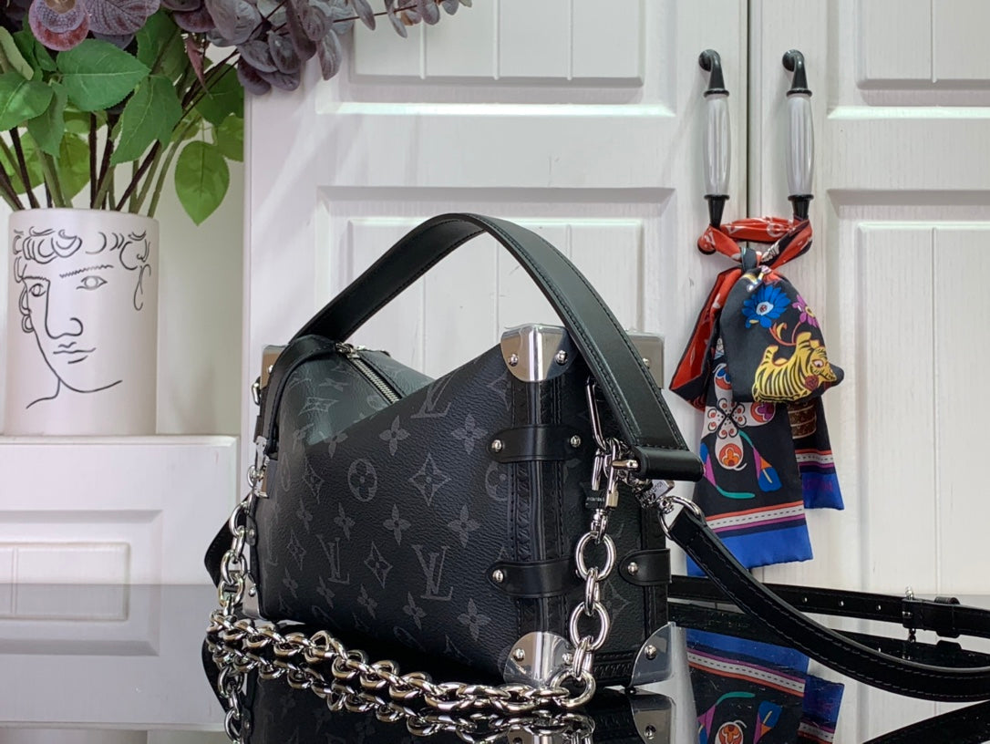 Dark monogram handbag with chain strap, top handle, and silver-tone corner details