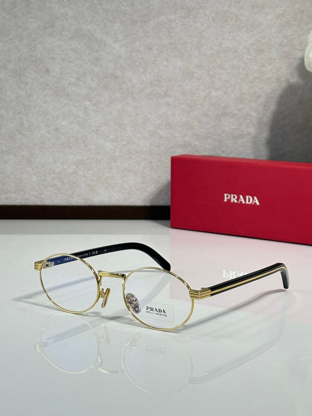 Round eyeglasses with clear lenses, gold frame and black temple arms