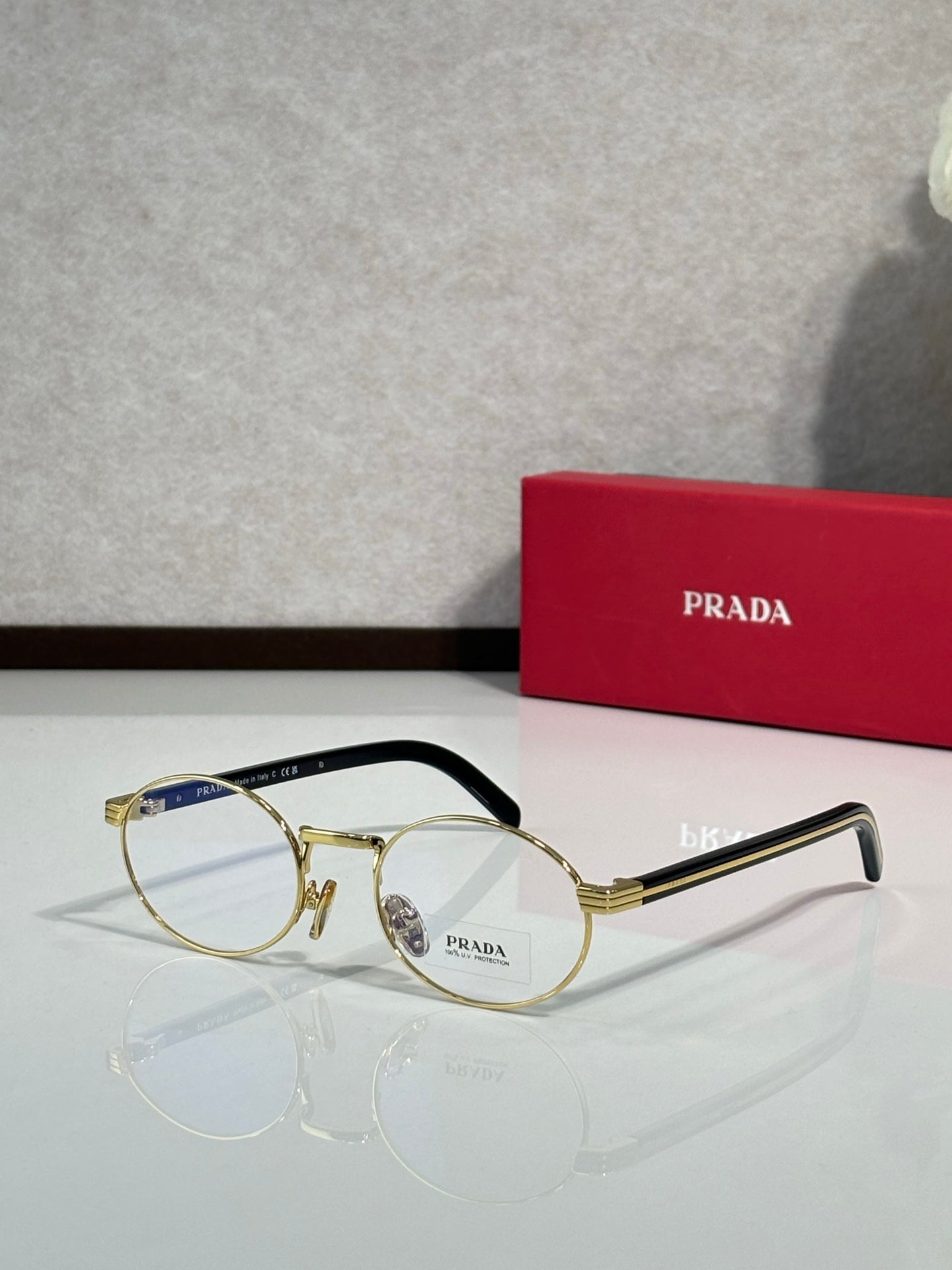 Round eyeglasses with clear lenses, gold frame and black temple arms