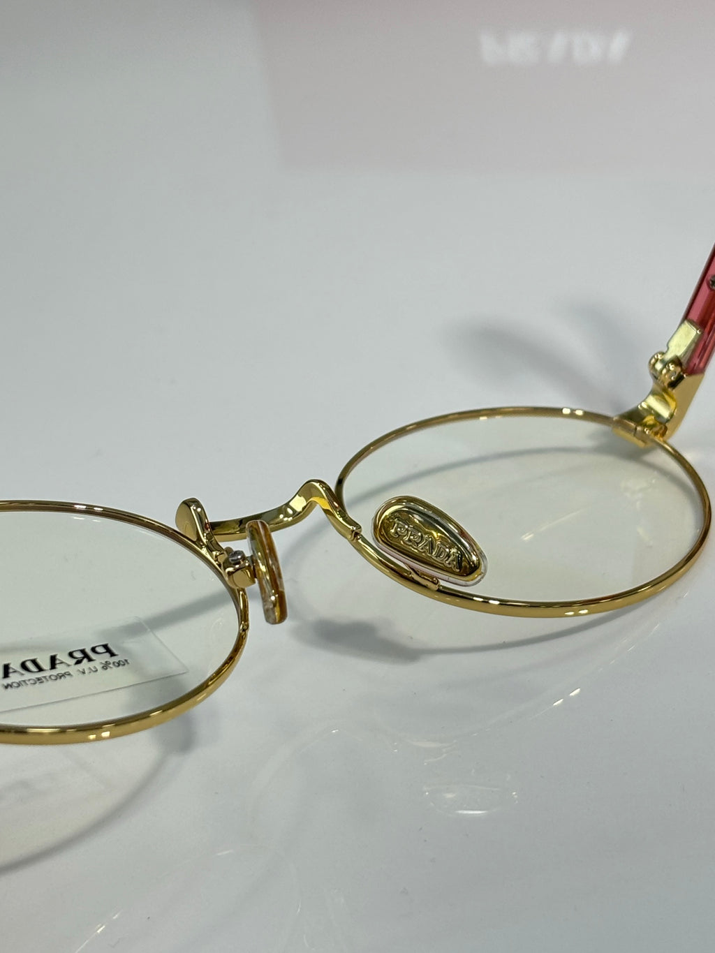 Round eyeglasses close-up with gold frame and oval nose bridge detail