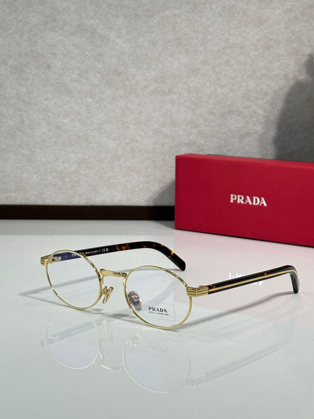 Prada eyeglasses with round clear lenses, gold frame and dark temples