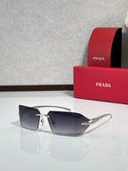 Prada sunglasses with smoky gray lenses and gold-tone temples.