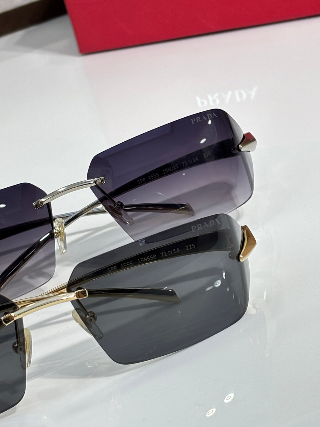 Prada sunglasses with dark, slightly purple-tinted lenses and gold hinges.