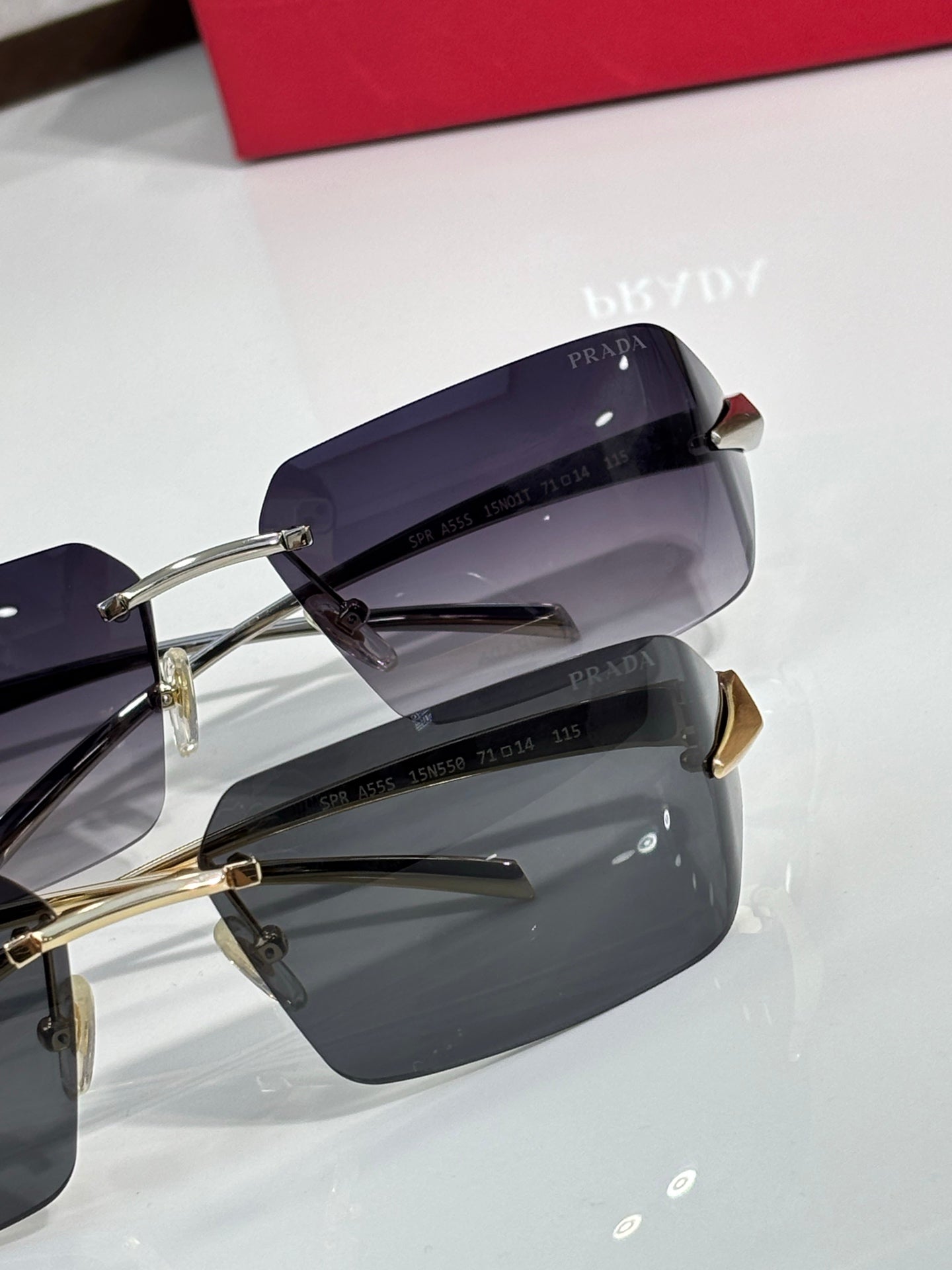 Prada sunglasses with dark, slightly purple-tinted lenses and gold hinges.
