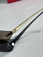 Prada sunglasses with gold-tone temples and engraved text near the hinge.