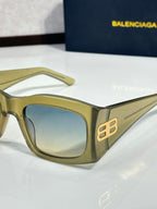 Balenciaga sunglasses with light blue-tinted lenses and gold acetate frame, gold logo