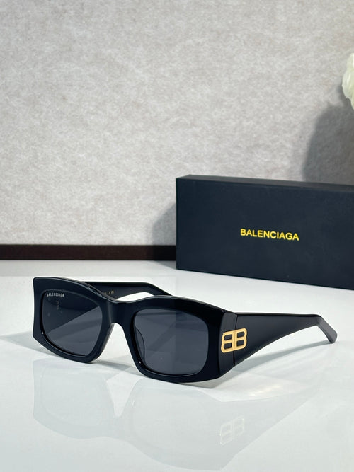 Balenciaga sunglasses with dark lenses and black acetate frame, gold logo detail