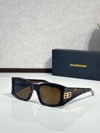 Balenciaga sunglasses with dark lenses and tortoiseshell acetate frame, gold logo detail