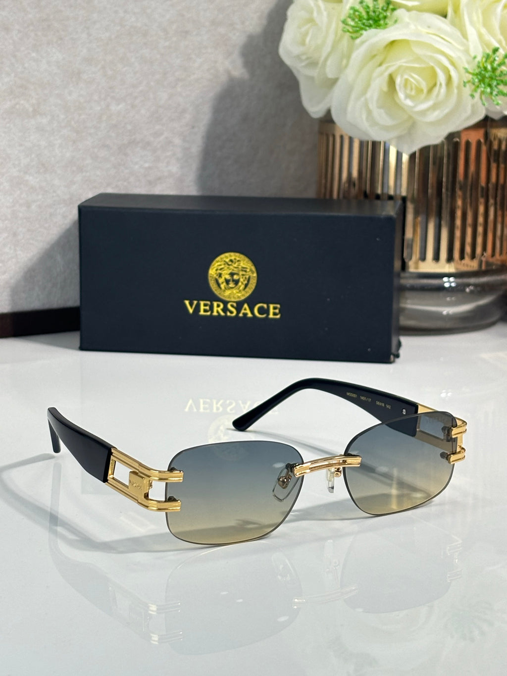 Gold-tone round sunglasses with light-gold gradient lenses and black temple arms