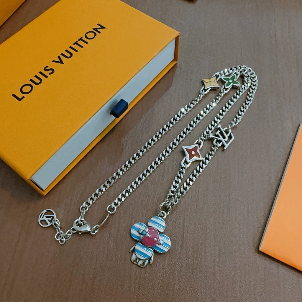 Charm necklace on display: silver chains with star and heart charms, enamel flower
