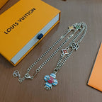 Charm necklace on display: silver chains with star and heart charms, enamel flower