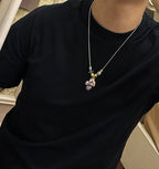 Silver-tone chain charm necklace with colorful character pendant and star charm at chest
