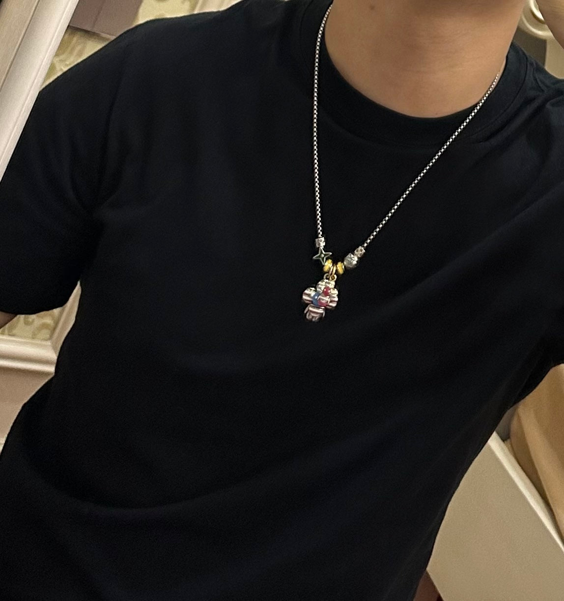 Silver-tone chain charm necklace with colorful character pendant and star charm at chest