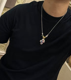 Silver-tone chain charm necklace with small colorful character pendant near the collar