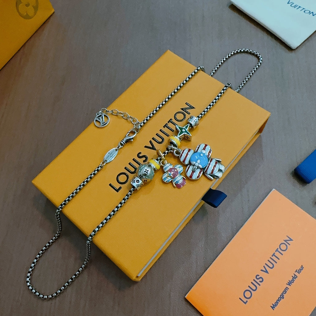 Silver-tone charm bracelet necklace with character charms and star pendant near clasp