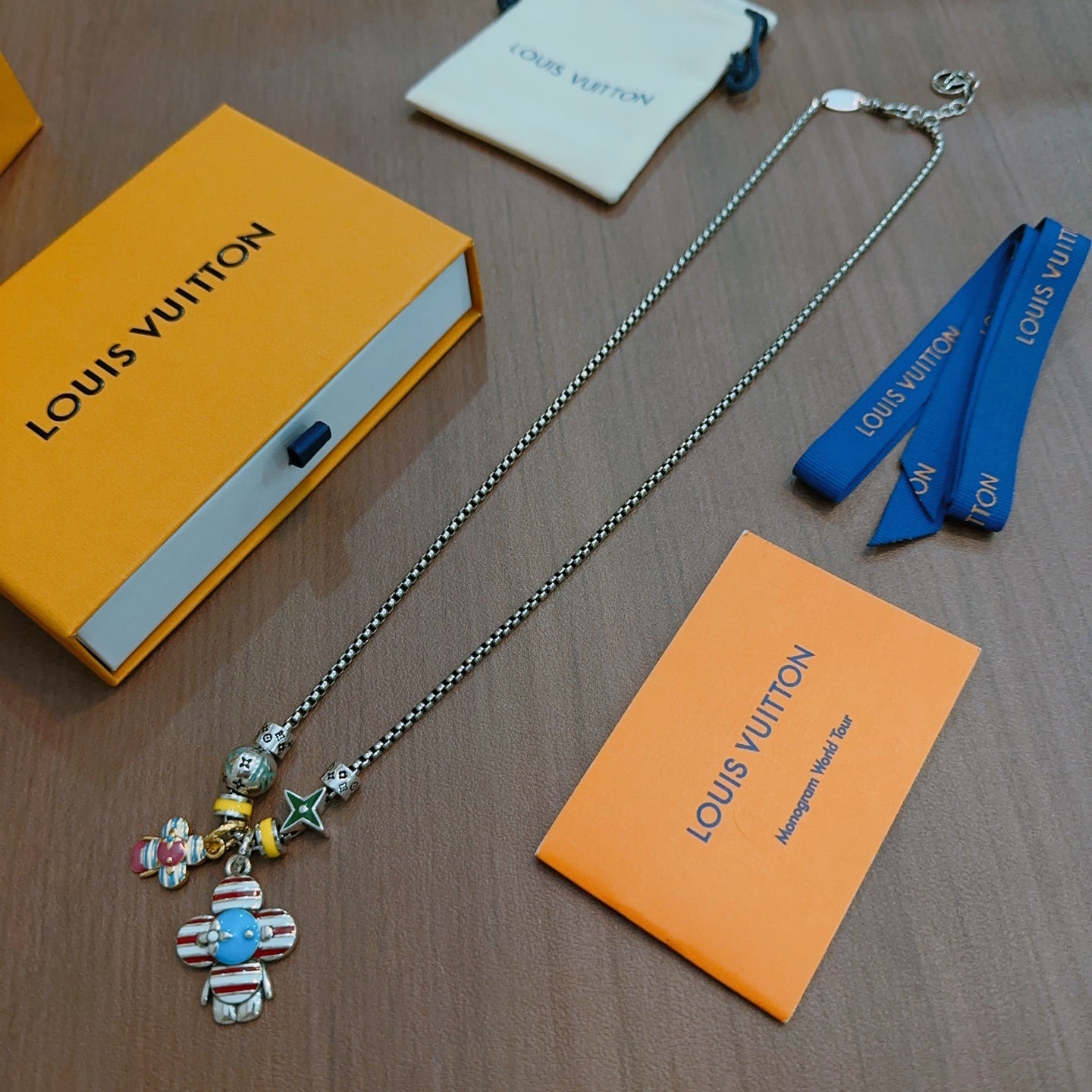 Silver-tone charm necklace with colorful character and star pendants on chain