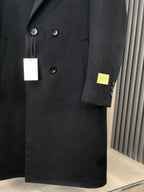 Black long coat close-up with button details and small Gucci patch on sleeve