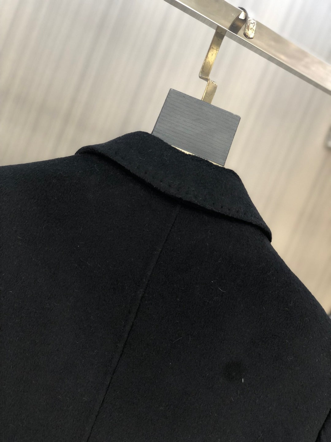 Black long coat close-up of raised collar and shoulder seam