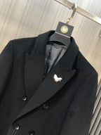 Black coat lapel with embroidered butterfly pin detail and dark button front