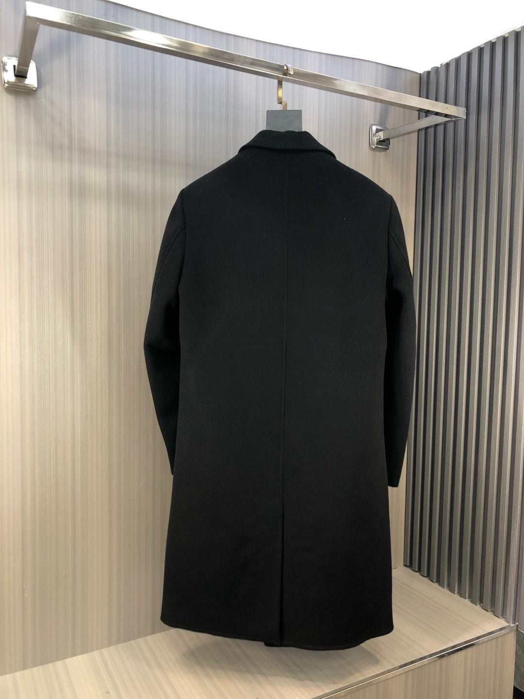 Black long coat with back seam and center back shaping, shown from the rear