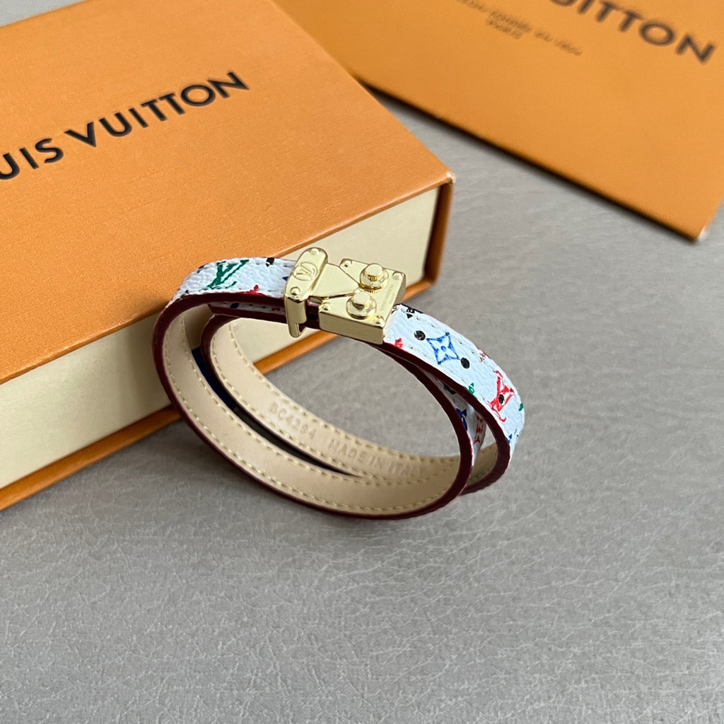 Louis Vuitton bracelet with multicolor print and gold clasp on cream leather strap.