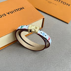 Louis Vuitton bracelet with multicolor print and gold clasp on cream leather strap.