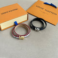 Louis Vuitton bracelets set with multicolor patterned strap and black leather strap, metal clasp.