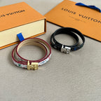 Louis Vuitton bracelets set with multicolor patterned strap and black strap, gold-toned clasps.