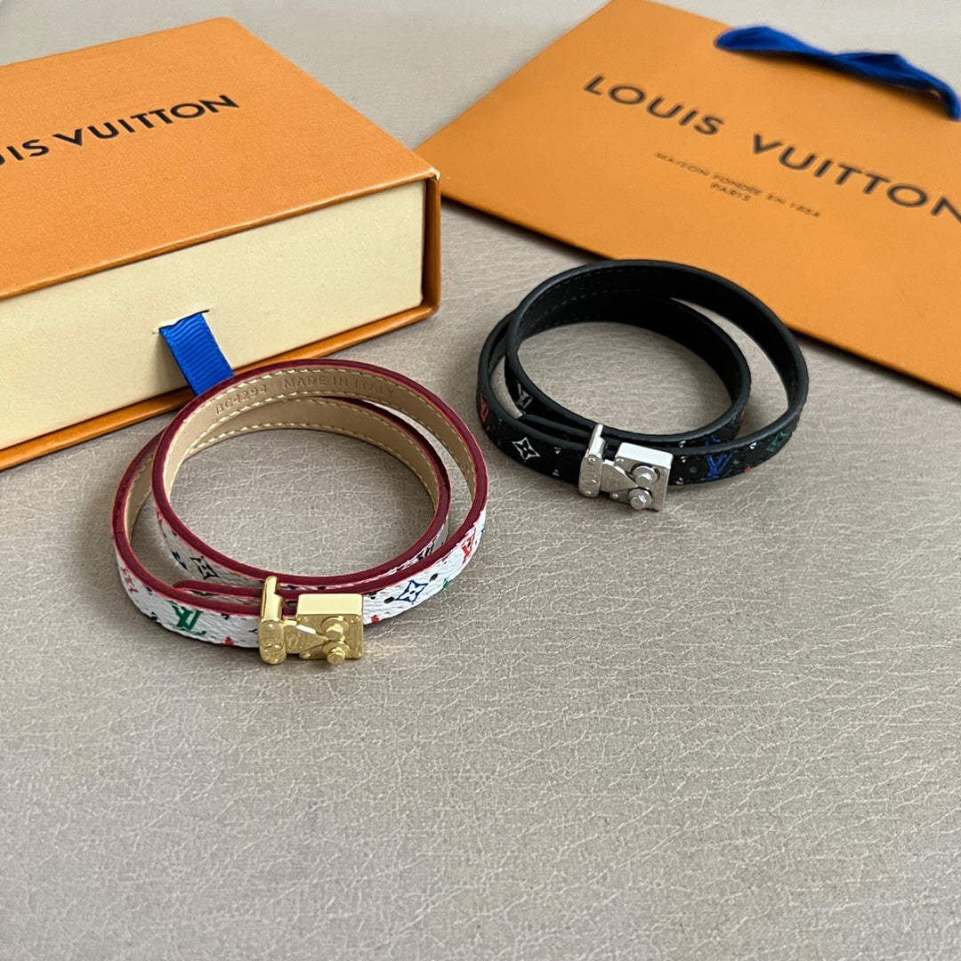Louis Vuitton bracelets set with multicolor patterned strap and black strap, gold-toned clasps.