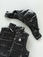 Black hooded puffer jacket with quilted panels and zip front; Moncler chest logo patch.