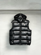 Black Moncler quilted puffer vest with hood, front zipper, and chest logo patch.