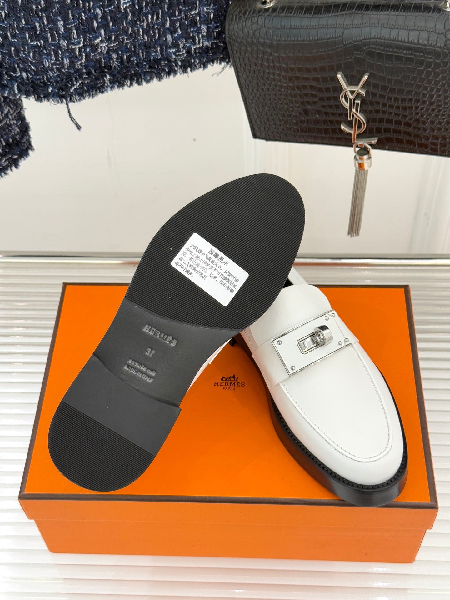 Hermes white leather loafer with sole view and silver buckle strap