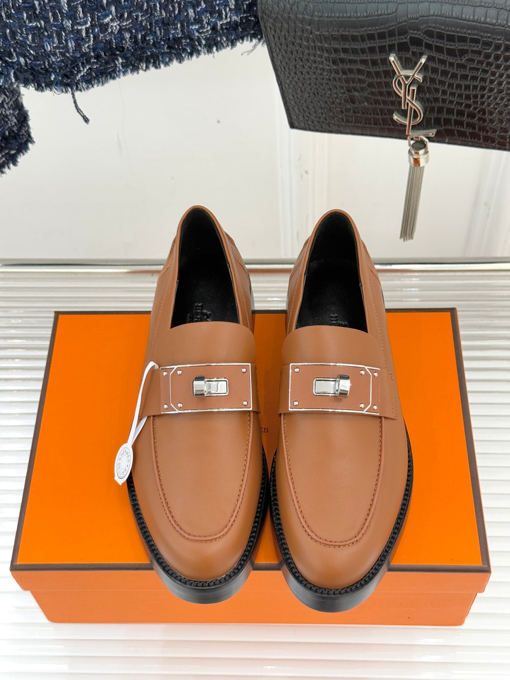 Hermes women’s tan leather loafers with square buckle detail and dark interior