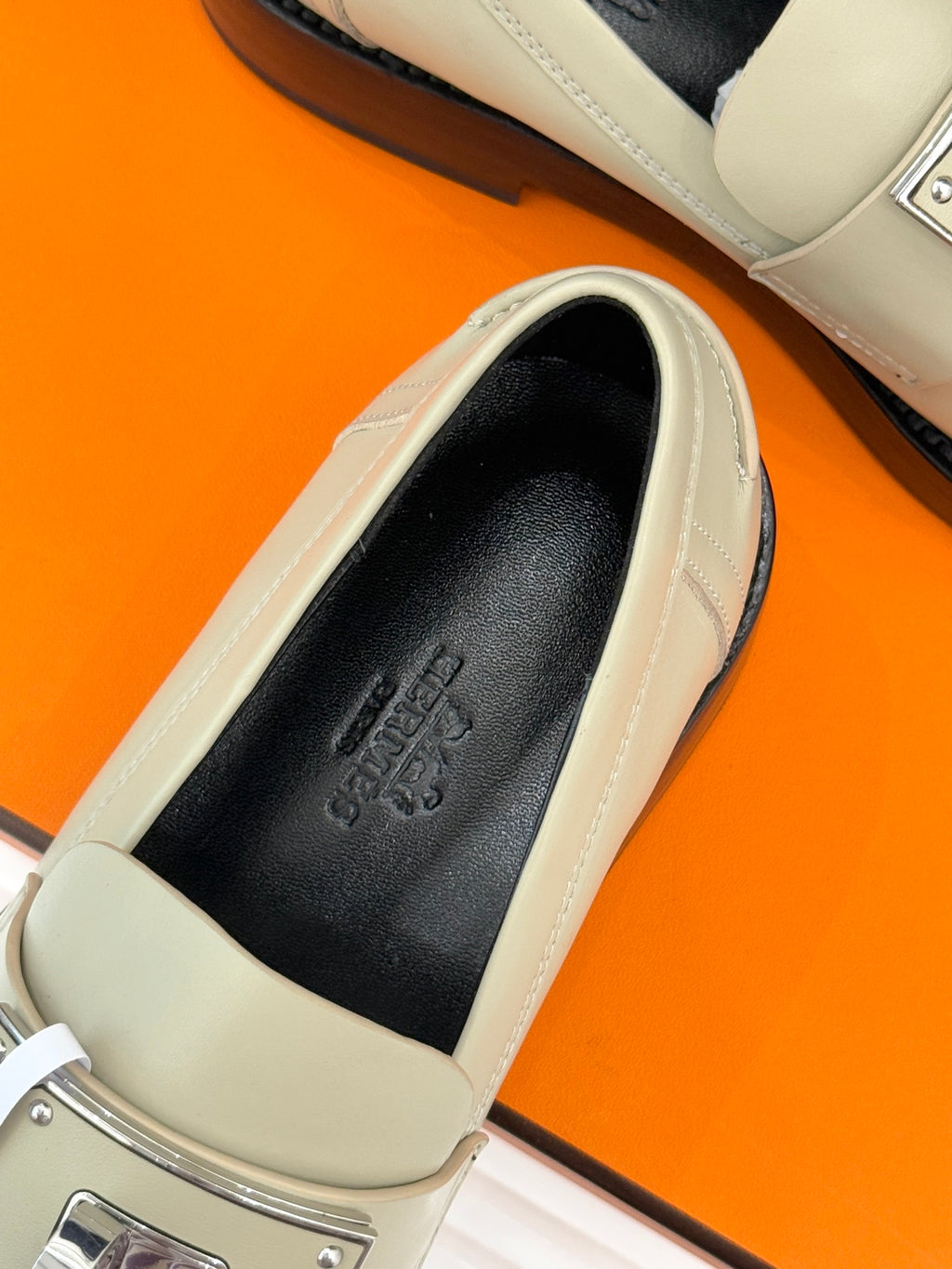 Hermes women's cream slip-on shoe close-up: black insole and stitched toe detail