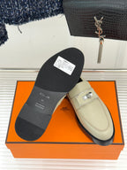 Hermes women's cream slip-on shoe showing outsole with black sole and silver buckle