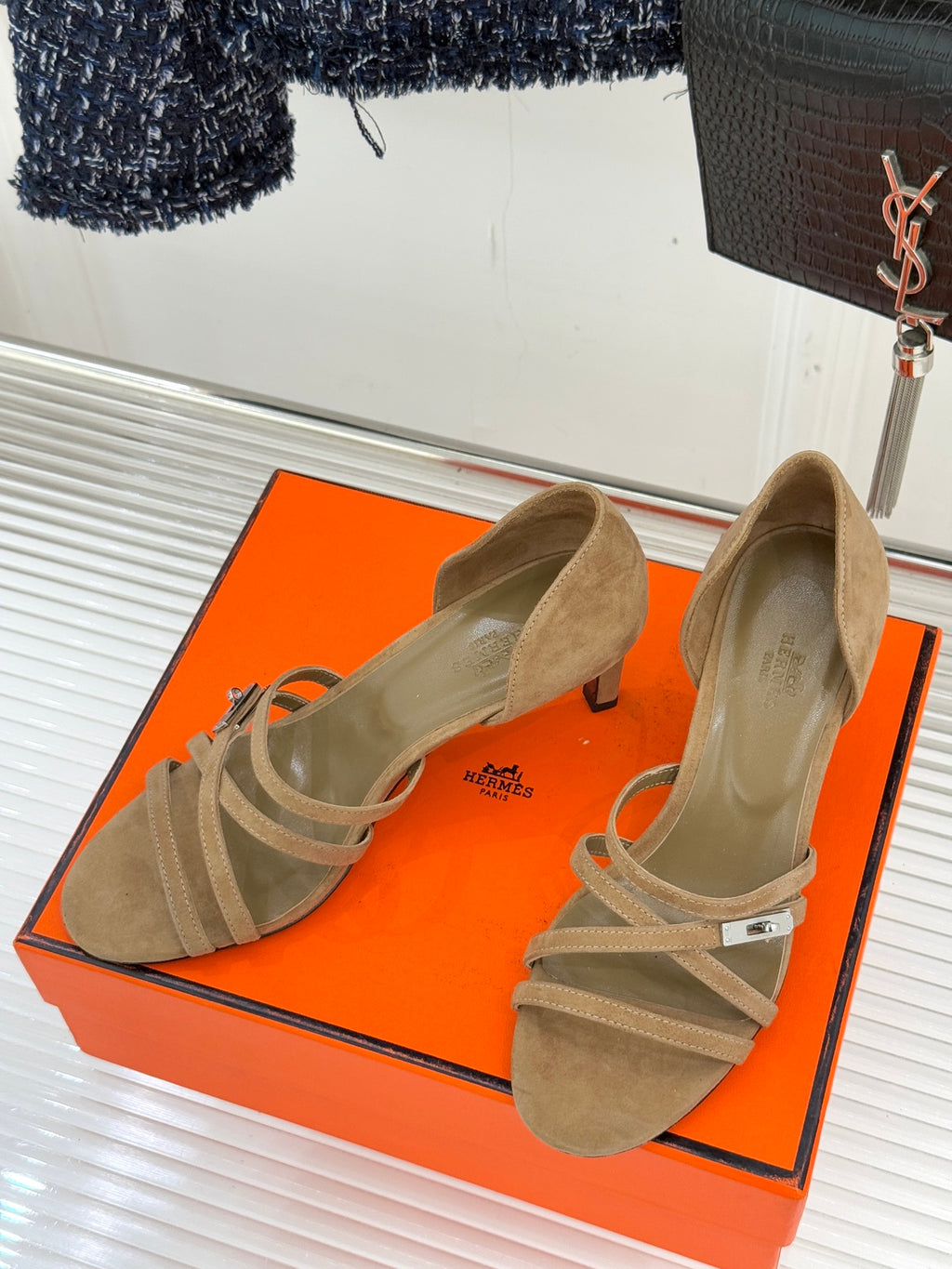 Beige suede heeled sandals with crossed straps and ankle wrap detail.