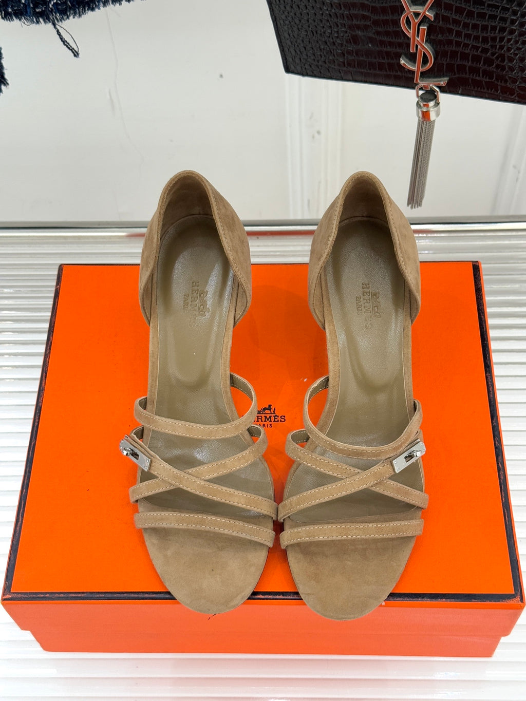 Pair of beige suede heeled sandals with crisscross straps and ankle buckle.