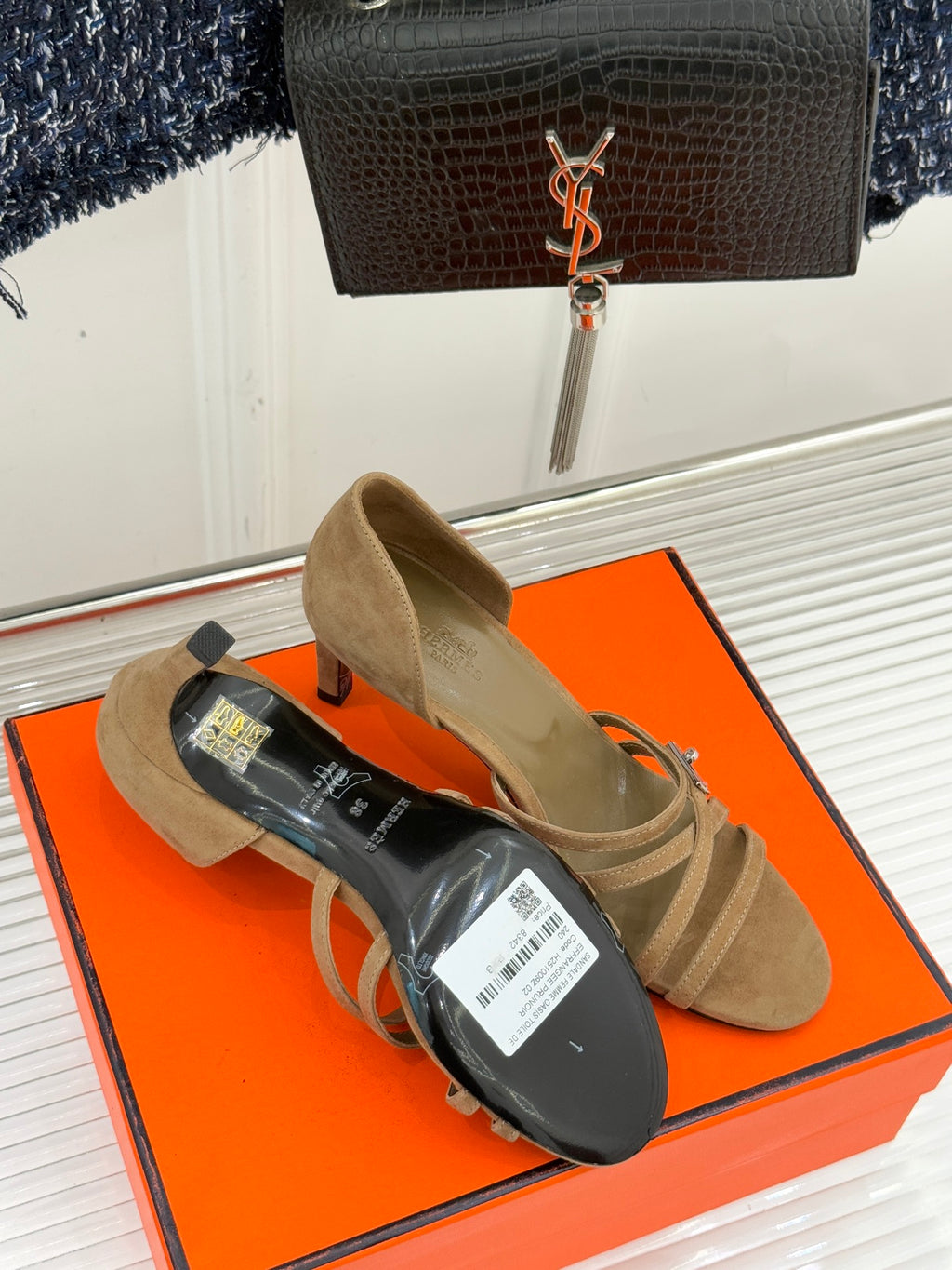 Beige suede heeled sandals shown with a pair of shoe box items underneath.