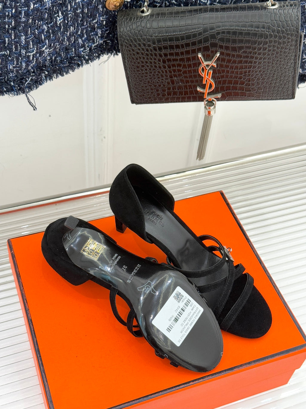 Black suede strappy high-heel sandals with toe straps and protective packaging