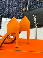 Orange suede slingback sandals with stiletto heels, open toe and curved straps.