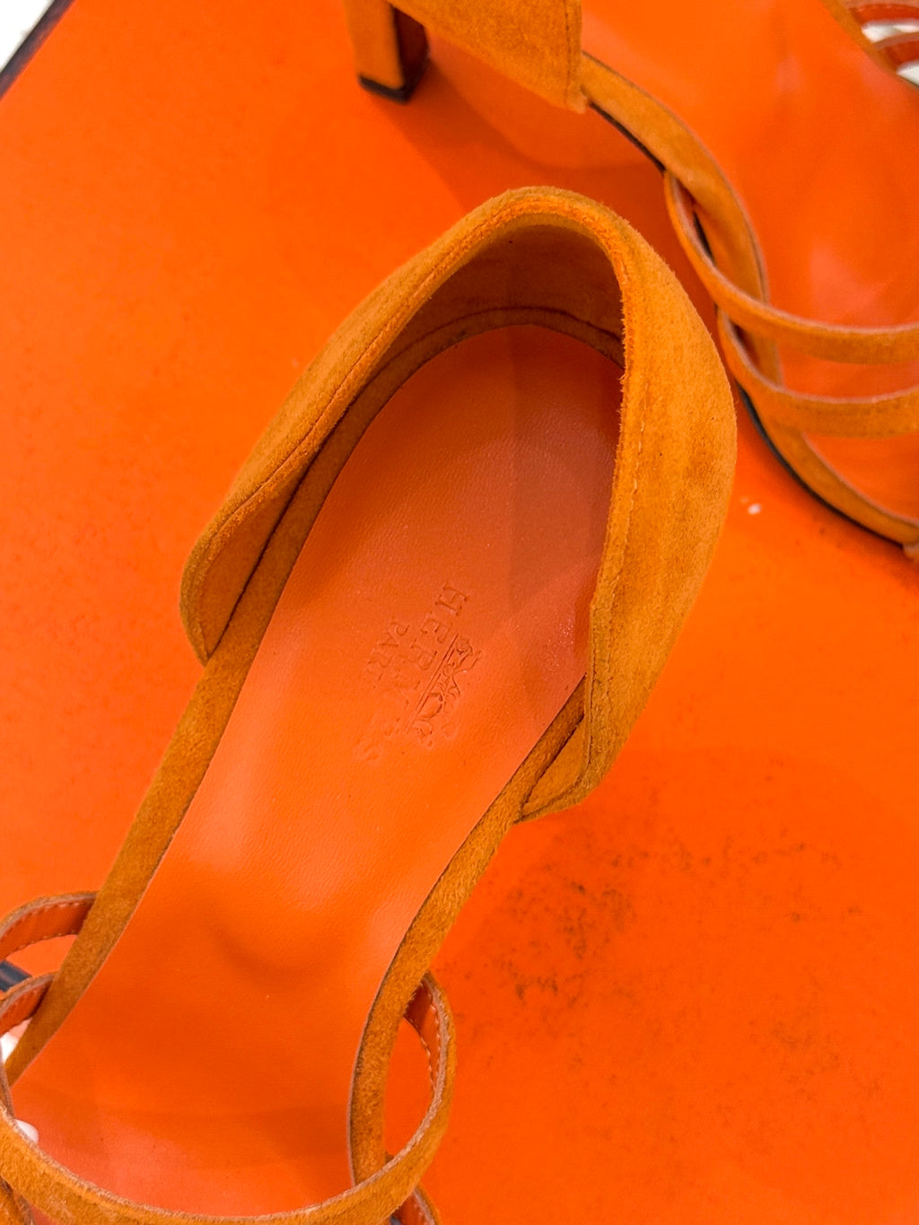 Orange suede sandal close-up of footbed and heel lining, slingback style.