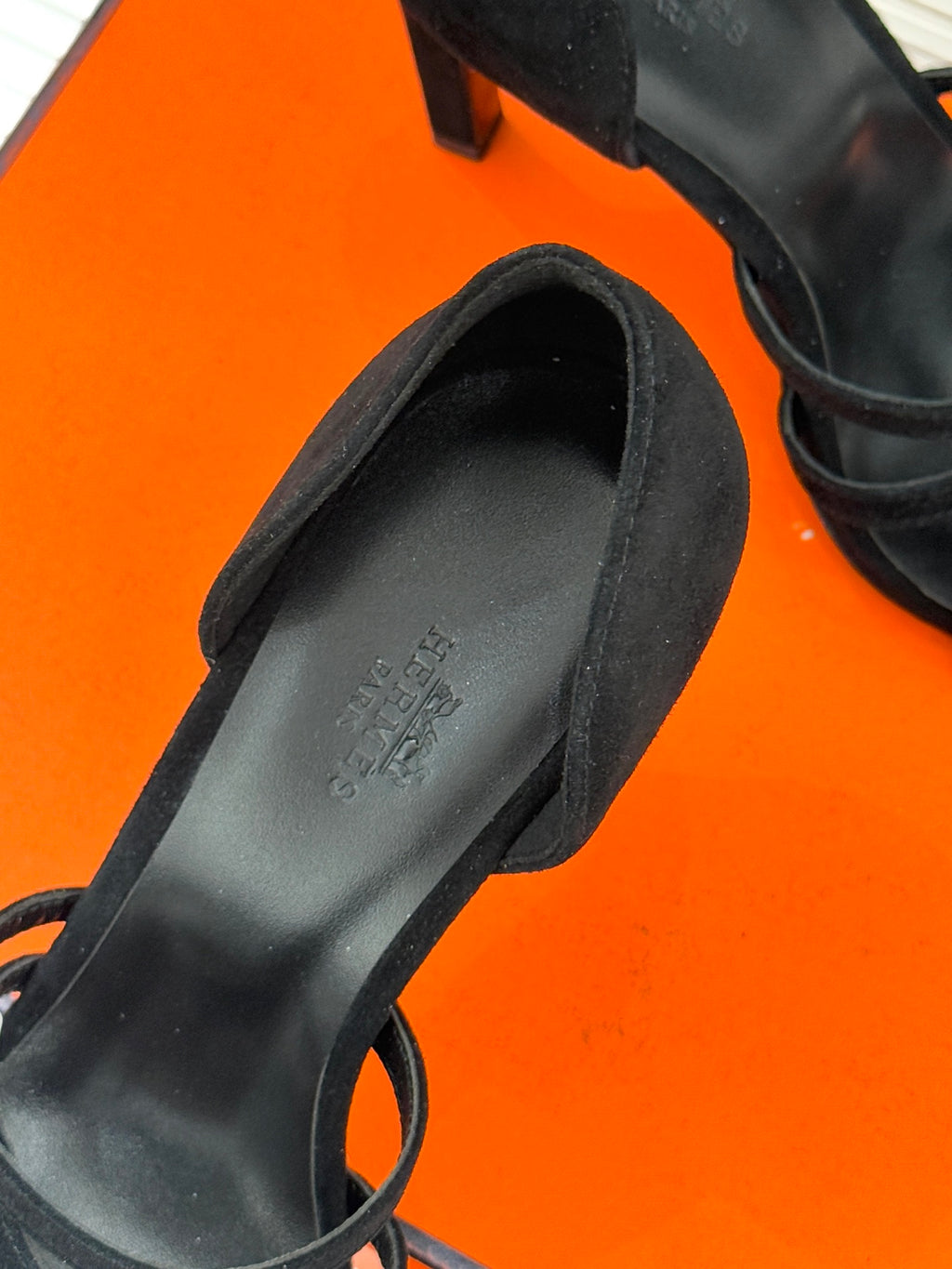 Close-up of black suede sandal footbed and ankle strap