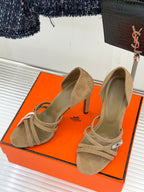 Hermes suede heeled sandals in tan with cross straps and small metal logo charm