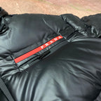 Long hooded puffer jacket with PRADA logo stripe across the chest