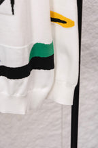 White sweater hem with multicolor striped panel on side