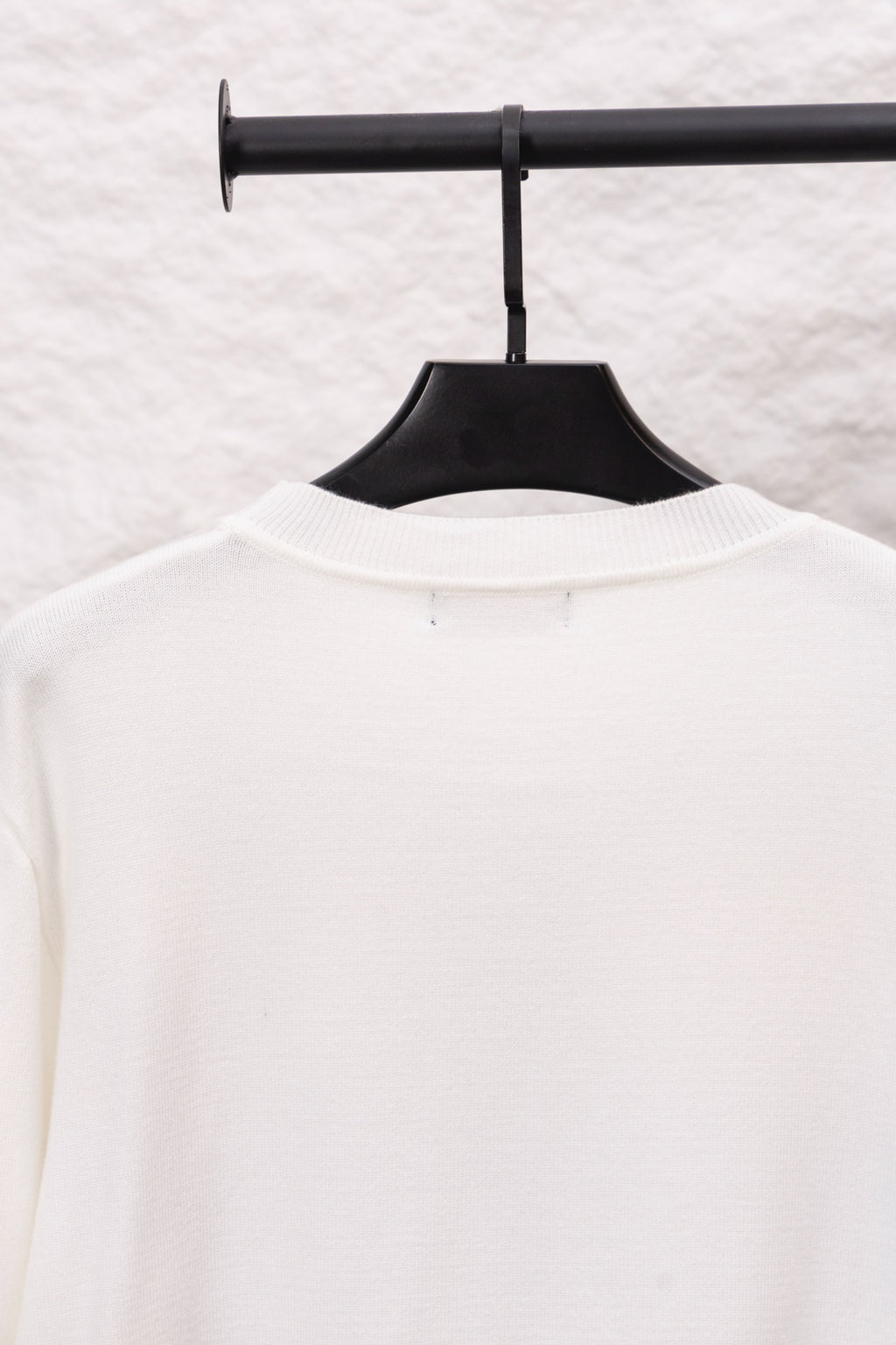 White long-sleeve crewneck sweater back view with small neckline tag