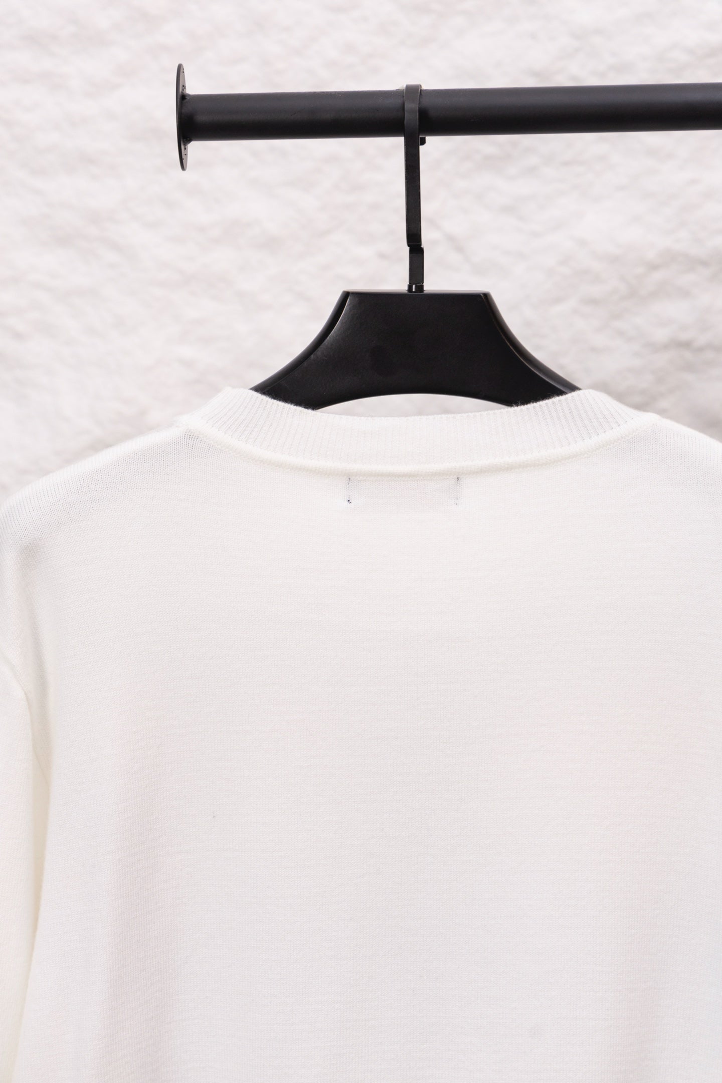 White long-sleeve crewneck sweater back view with small neckline tag